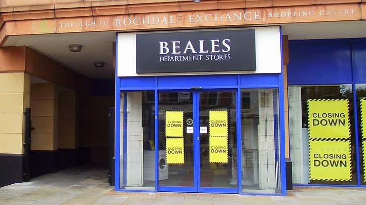 A Beales store stands empty with signs advertising a closing down sale.