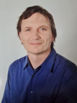 Profile picture of Alan Wheeler, CEO of the Textile Recycling Association. Alan is a white male with brown hair, wearing a blue shirt. Alan is looking straight to camera. 
