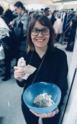 Picture of Heidi at the sample sale, holding a bowl of money. 