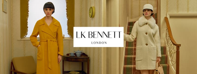 A lady dressed in a yellow coat stands in front of a window. A woman in a white coat and a white hat stands in front of a staircase. The LK Bennett logo in the middle.